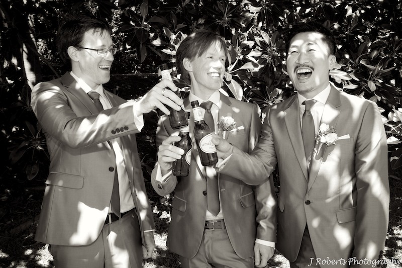 Groom and groomsmen celebrating - wedding photography